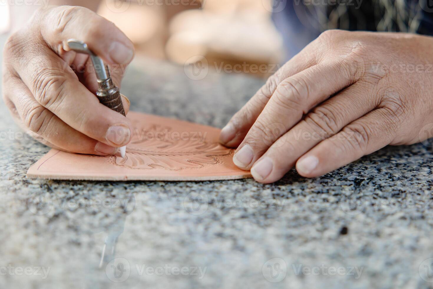 closeup hand working process leather handcraft in the leather workshop. Man holding crafting tool and working. He is sewing hammer to make a wallet. Tanner in old tannery. photo