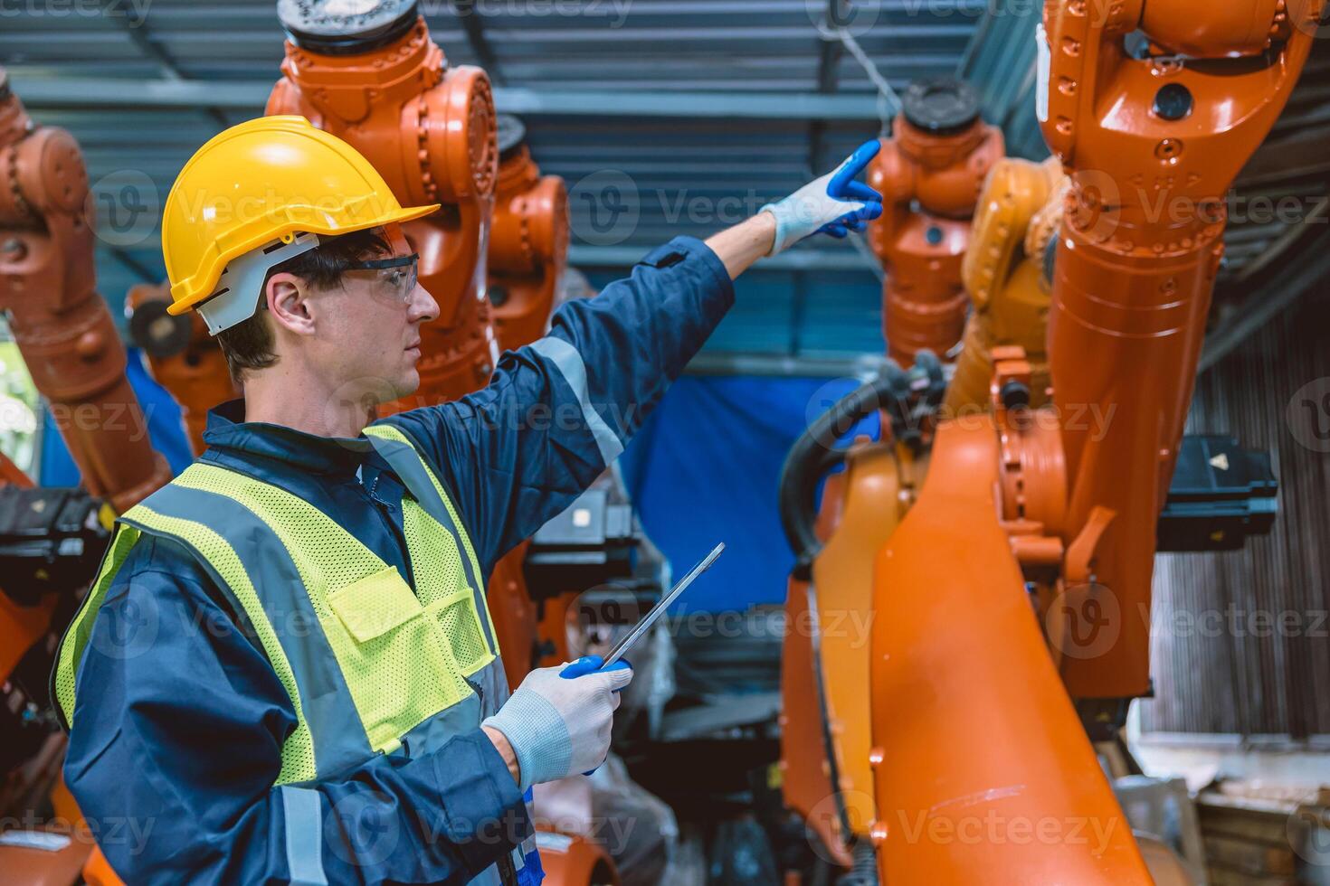professional engineer male caucasian working with automated robotic arm for modern industry factory technology photo
