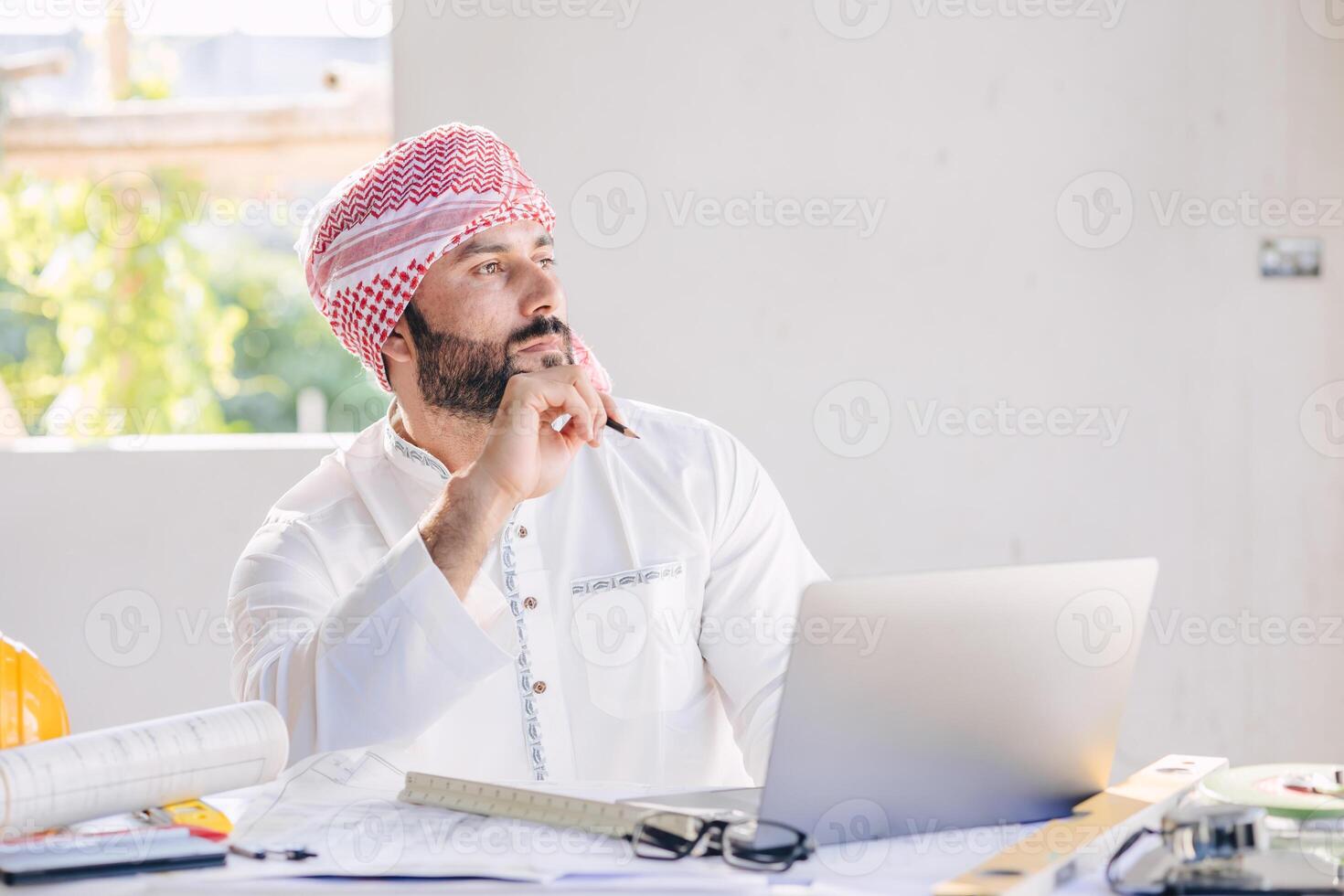 Arab construction engineer architect working at construction site with building floor plan looking out for thinking new idea project vision photo