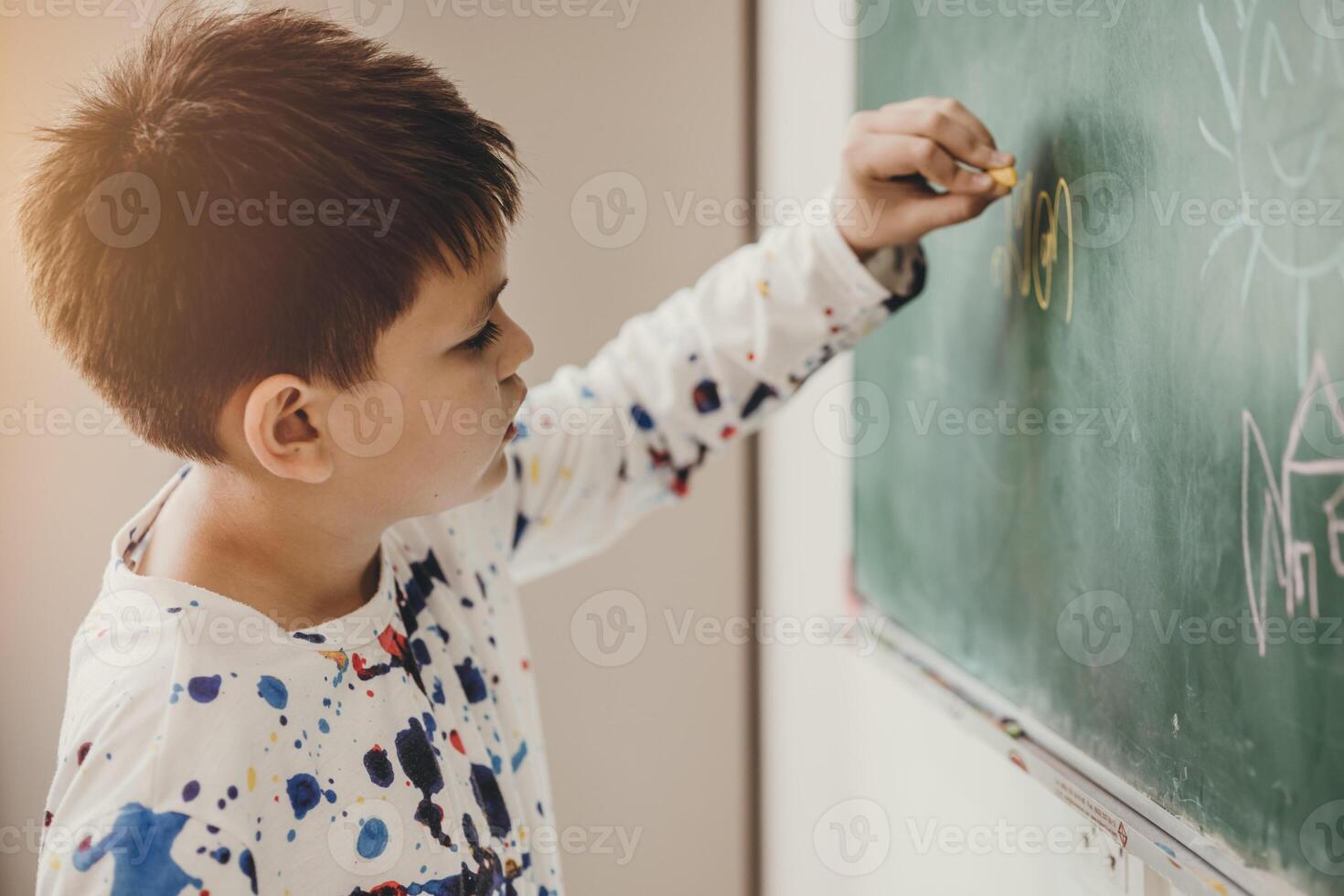 Asian boy happy smile enjoy education at school in classroom writing answer at chalkboards photo