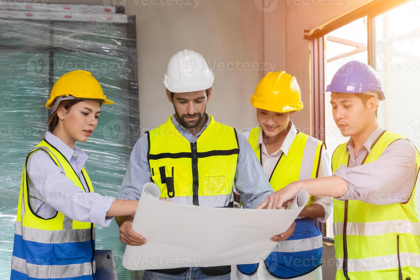 group of construction worker team working together discussion looking floor plan at construction site planning build process photo