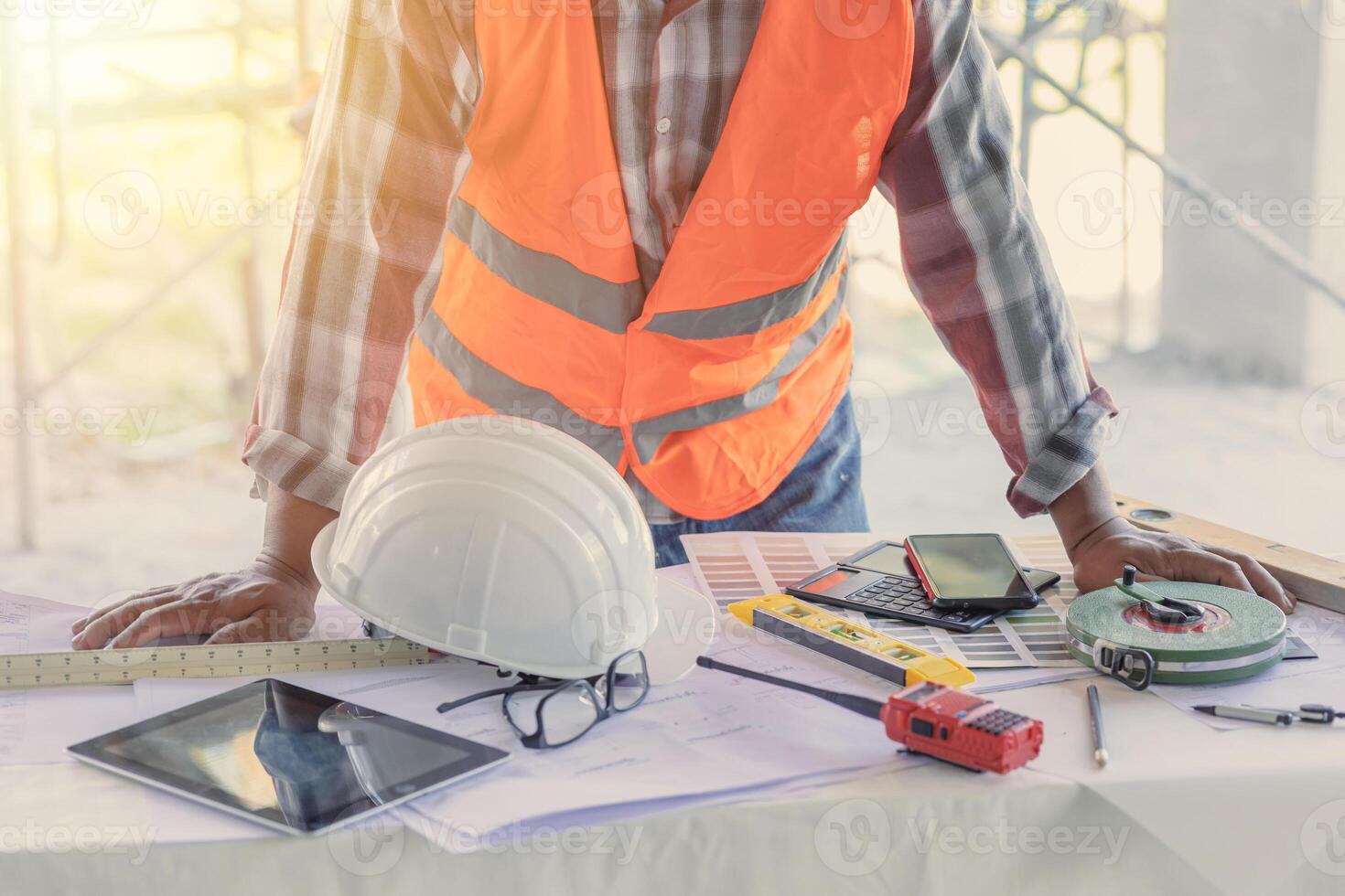 Engineer builder desk working space in construction site with floor plan or blueprint of building photo