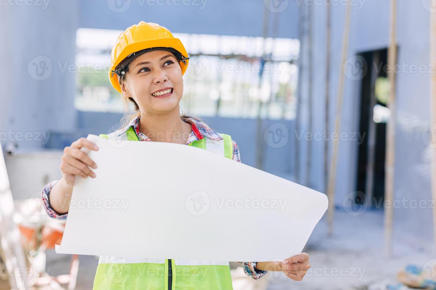 Asian woman engineer worker work in construction site. Smart builder architect female in safety suite working. photo