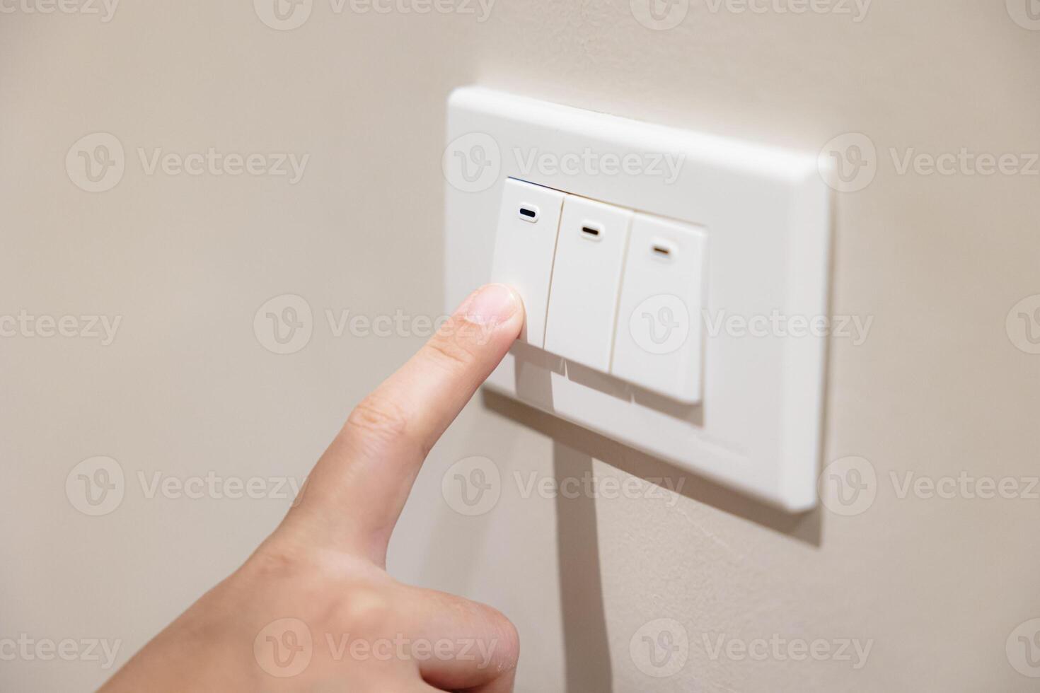 people press light switch to turn off the light for saving home energy reduce utilities billing cost photo