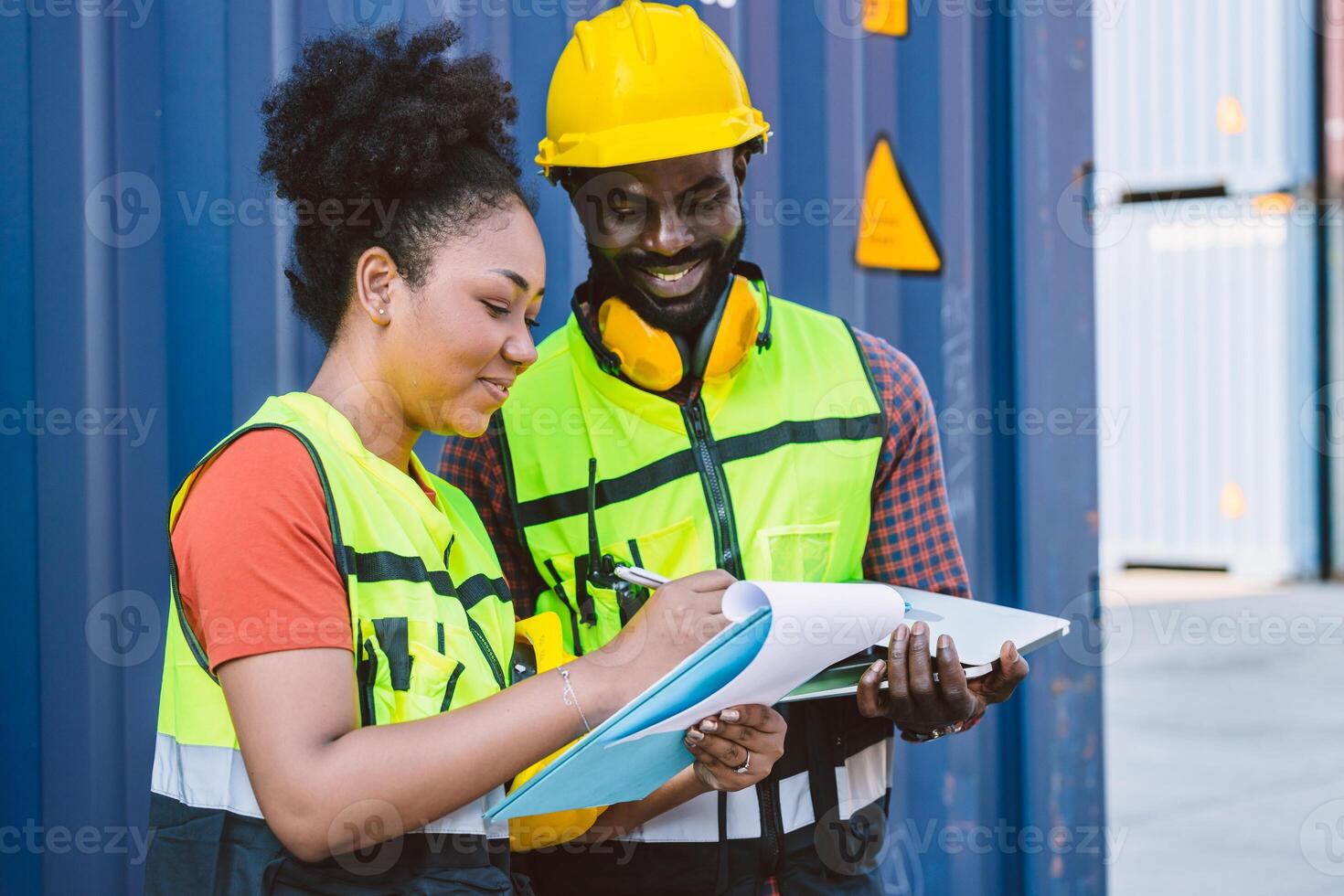African American couple customs team staff worker working together with check list shipping order at port container yard enjoy work happy smile photo