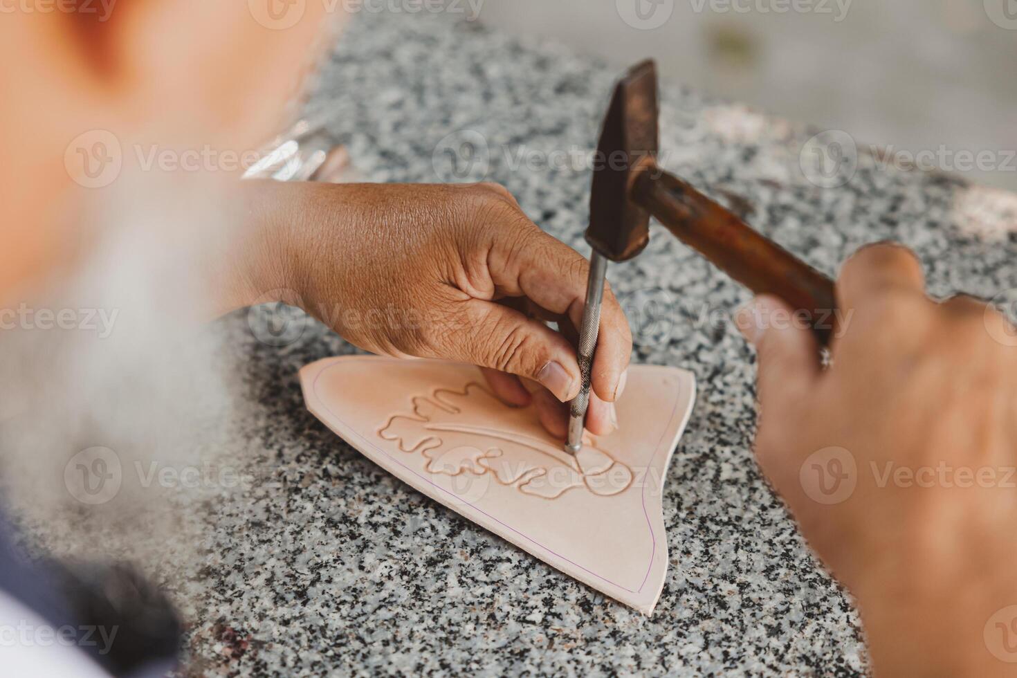 de cerca mano trabajando proceso cuero artesanía en el cuero taller. hombre participación elaboración herramienta y laboral. él es de coser martillo a hacer un billetera. curtidor en antiguo curtiduría. foto