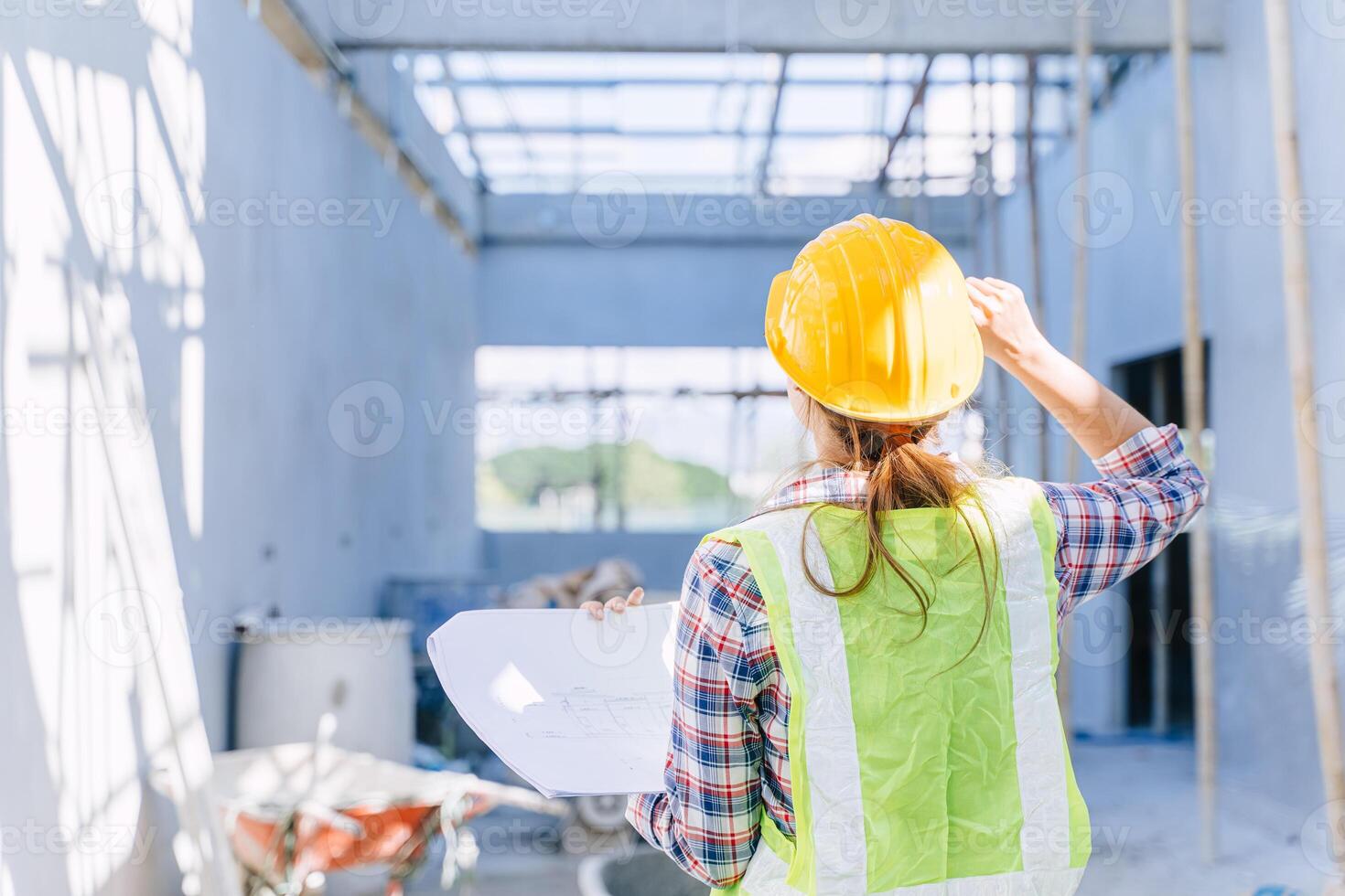 Female engineer working women. Architect construction builder worker with floor plan at building site. photo