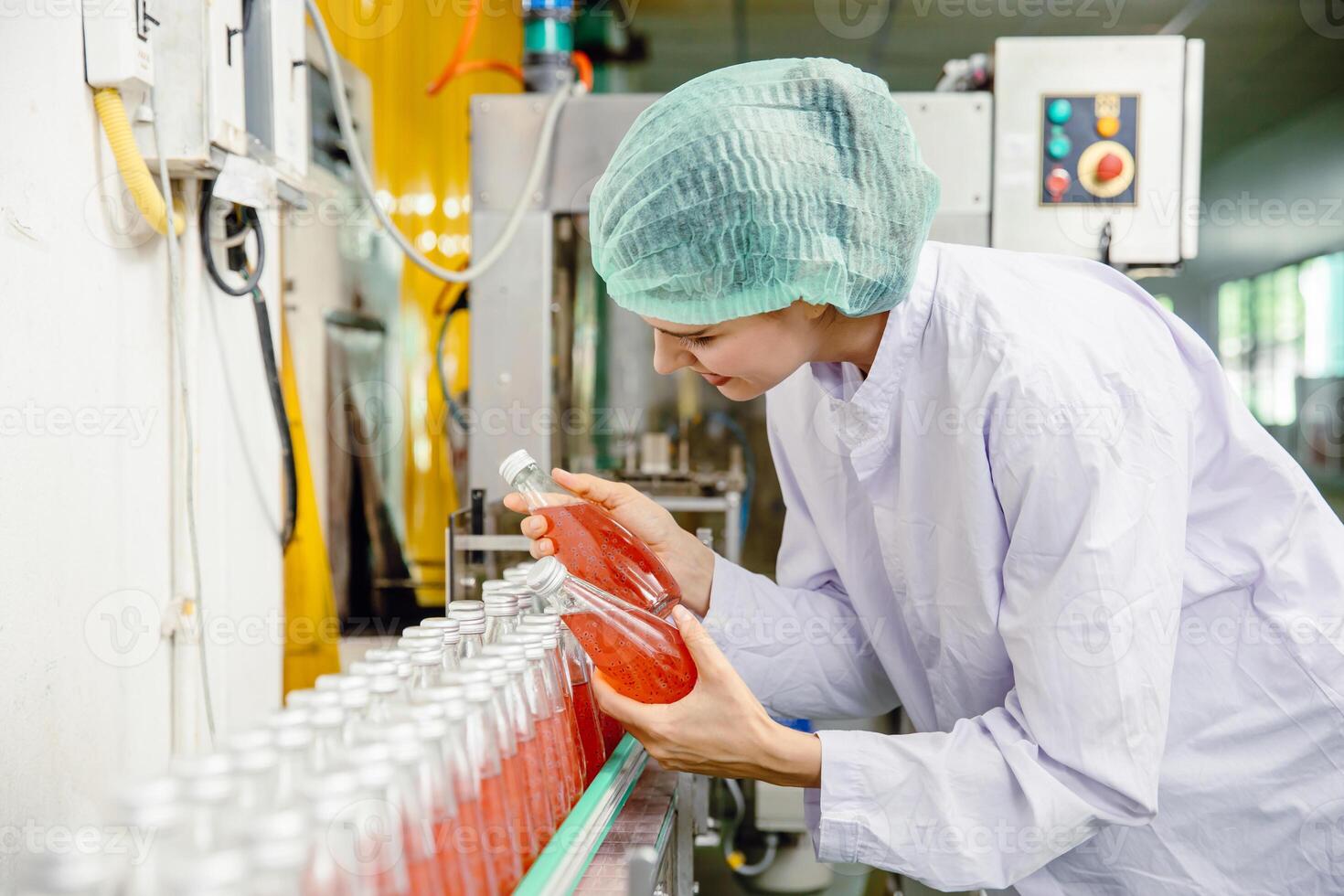 food and drink industry staff worker working at conveyor belt production line machine in beverage factory with clean and hygiene area. photo