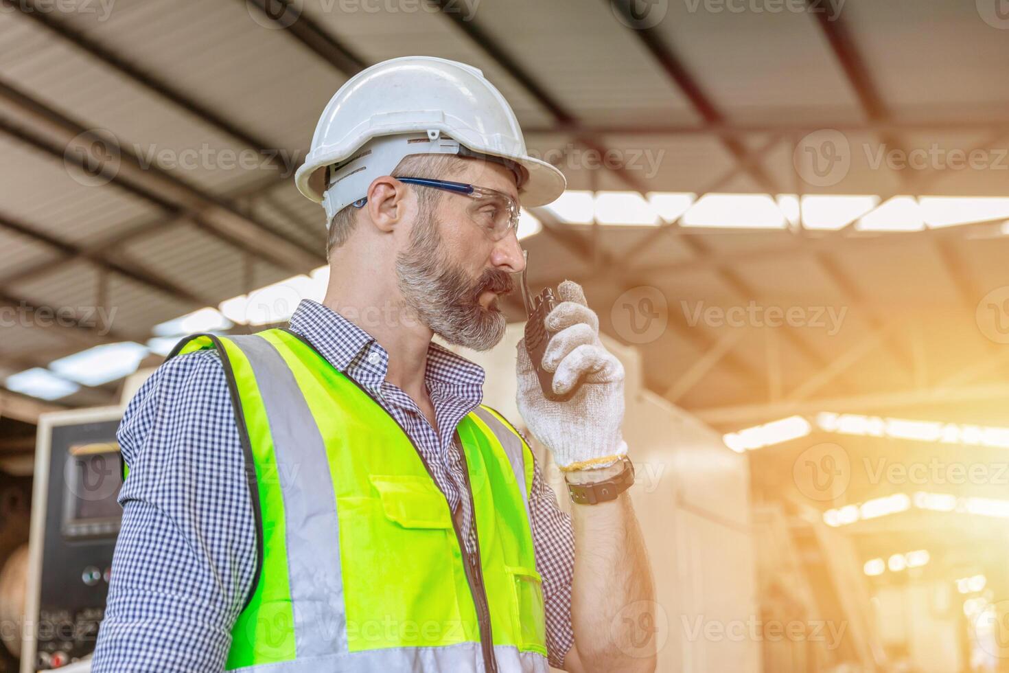 hispanic indian male engineer worker supervisor working in heavy industry smart radio call photo