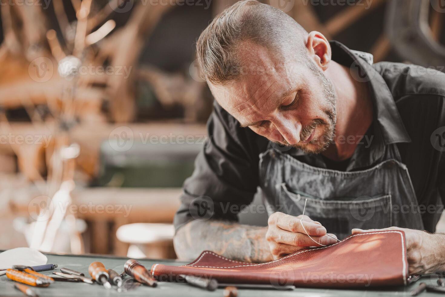 Leather maker artist handcraft working at own workshop small studio made by order masterwork piece photo
