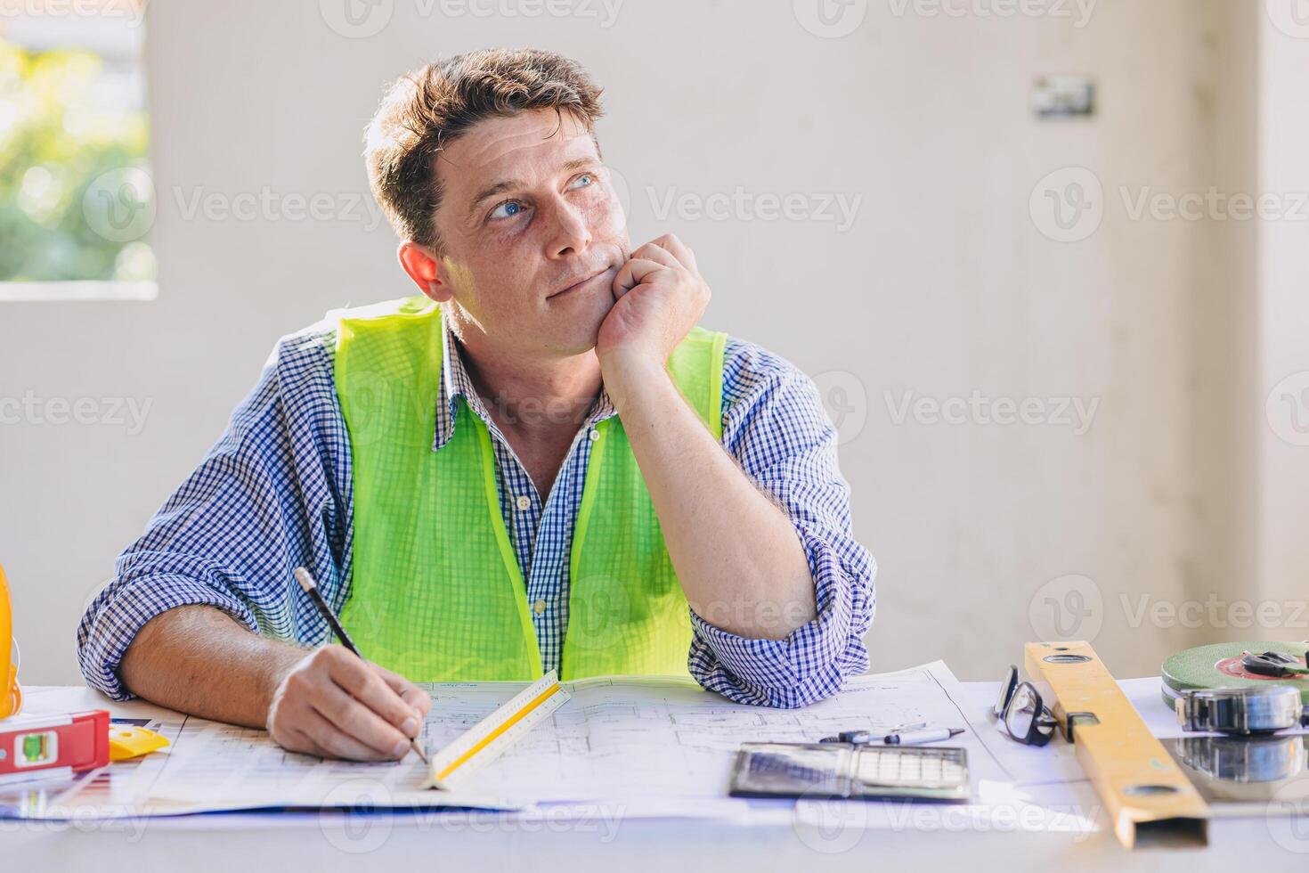 Construction engineer architect working at construction site with building floor plan looking out for thinking new idea project vision photo