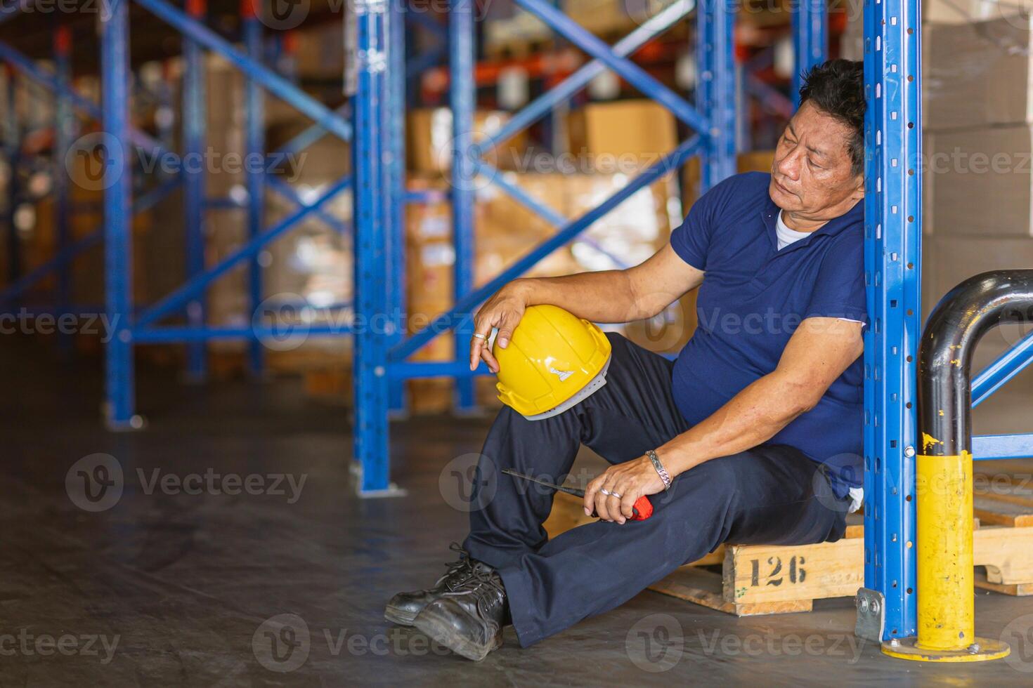 fatigue senior adult worker napping sleep at work exhausted. warehouse industry employee sleeping tired from hard working. photo