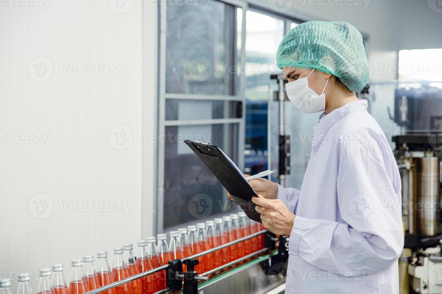 food and drink industry staff worker working at conveyor belt production line machine in beverage factory with clean and hygiene area. photo