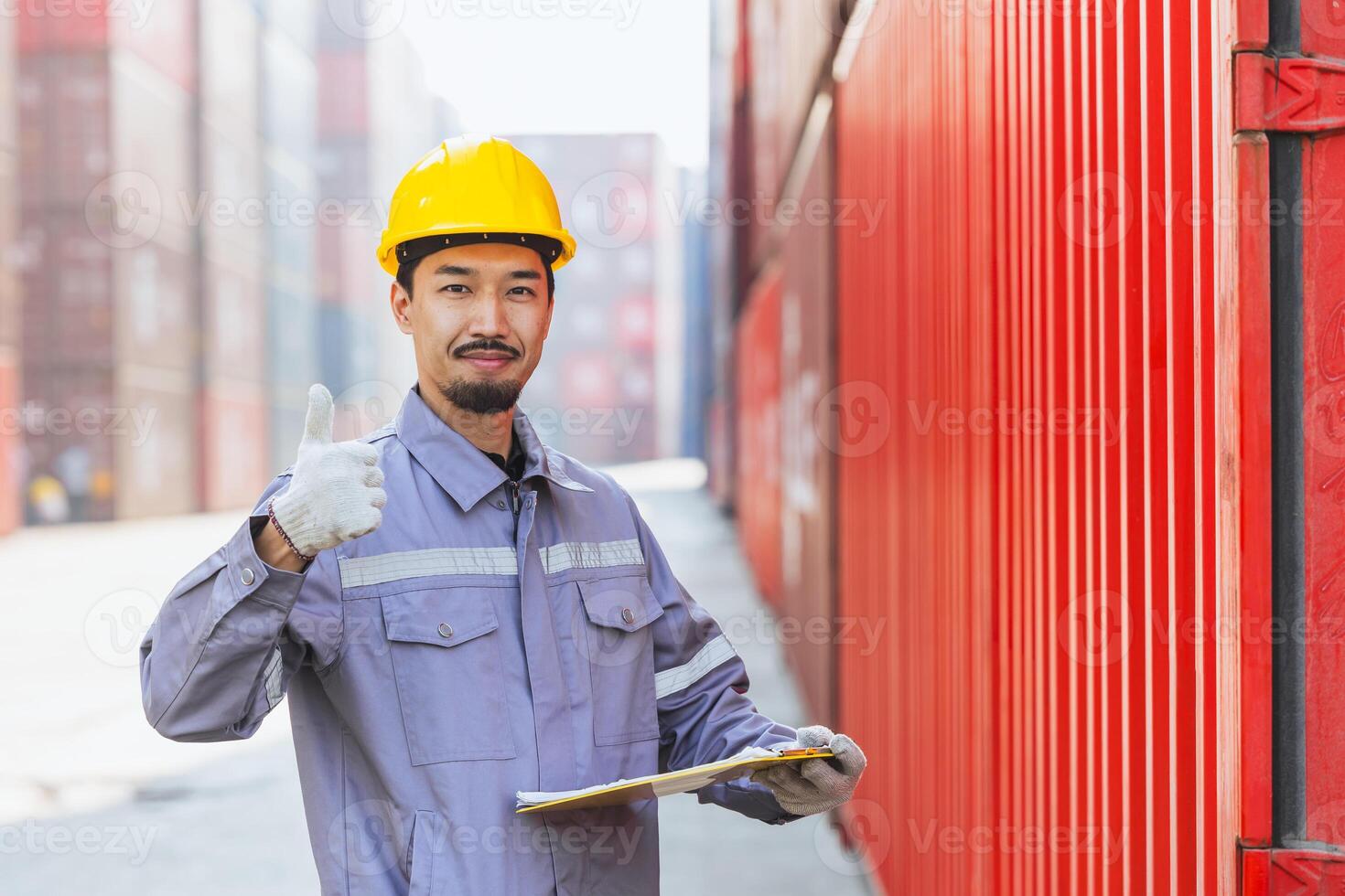 Portrait happy Japanese male engineer worker working in container port cargo. Japan shipping logistics industry customs staff people. photo