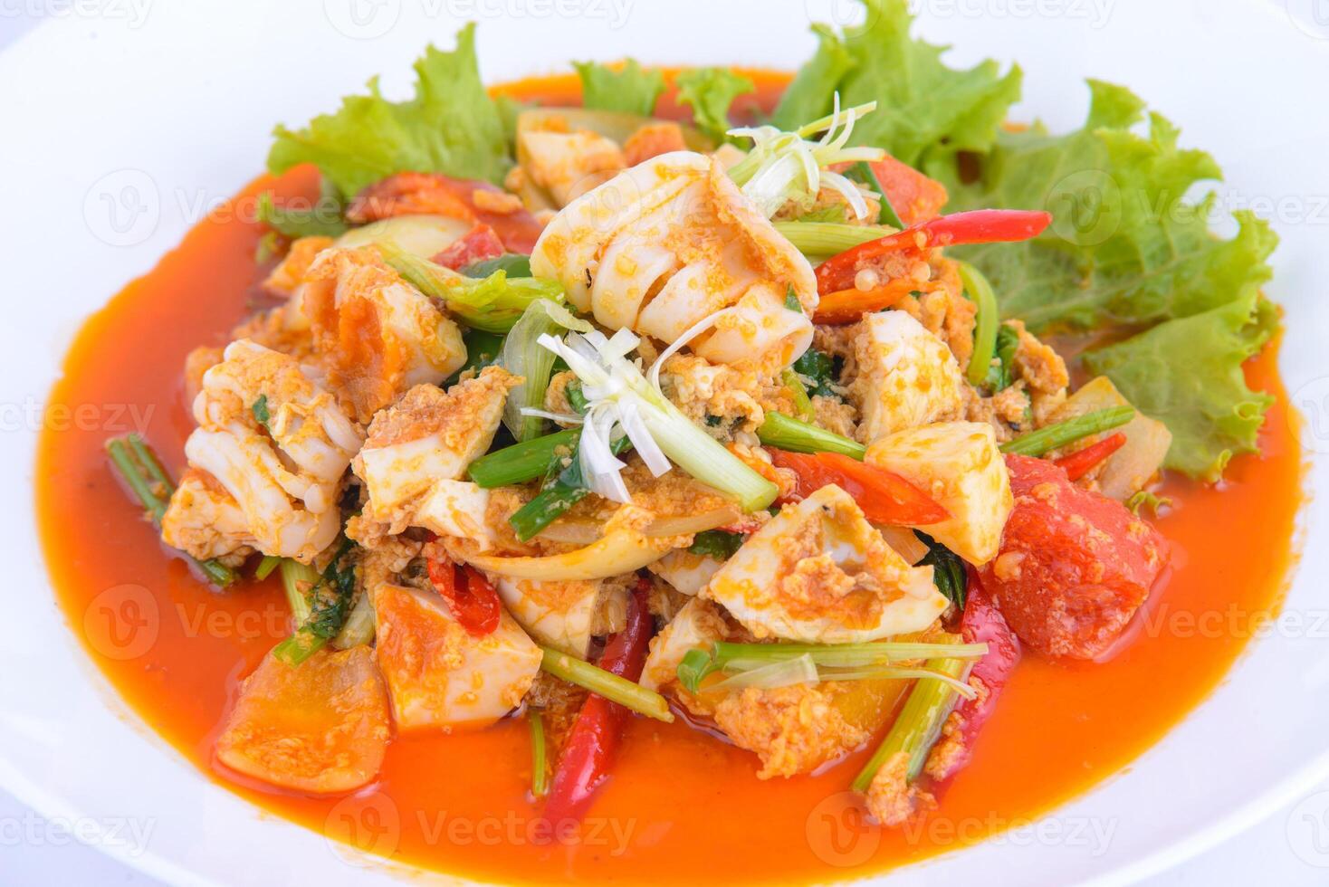 Thai favourite food. Stir Fried Squid with Curry on the white dish. photo