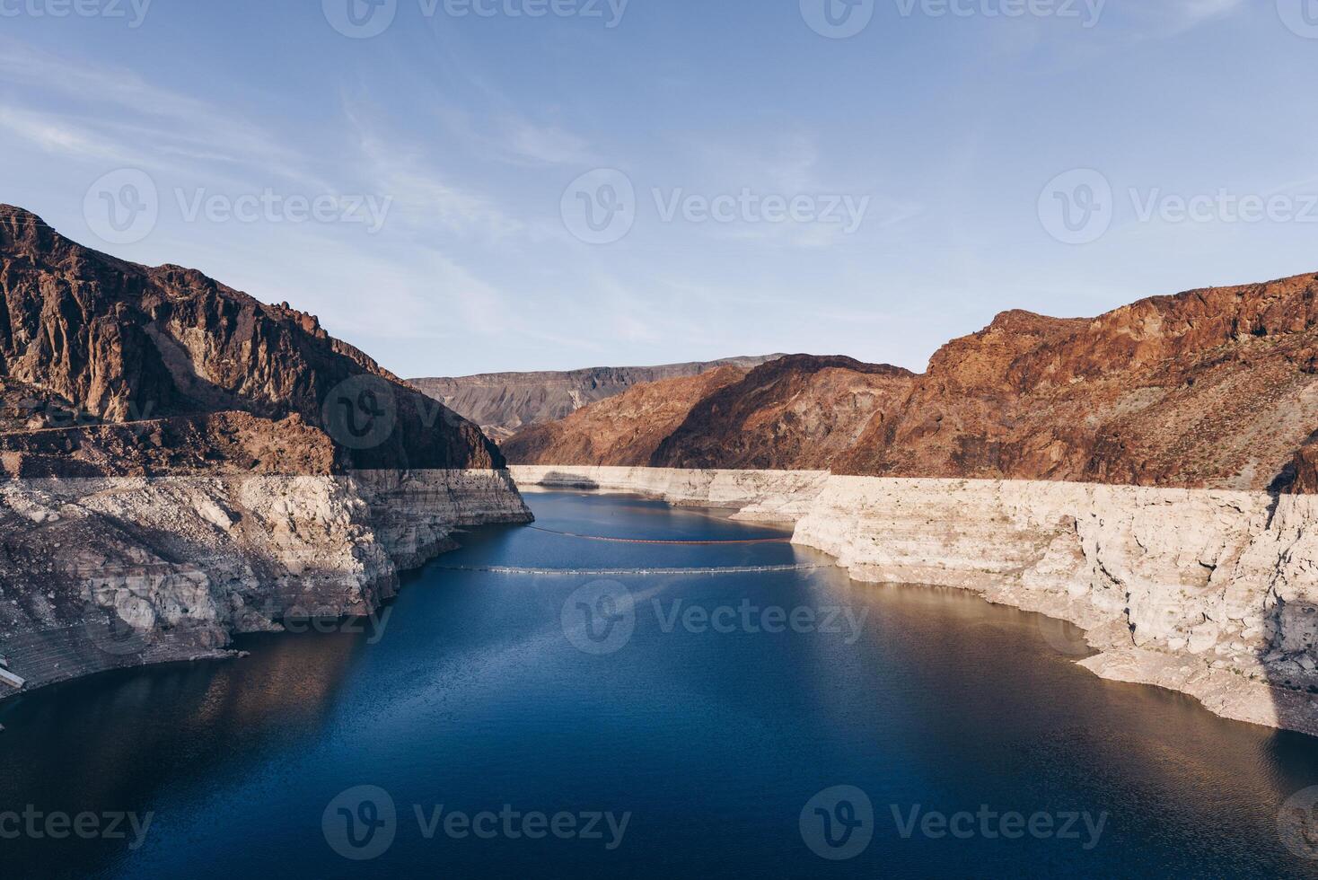 puro azul lago Entre el rocas detrás el represa foto