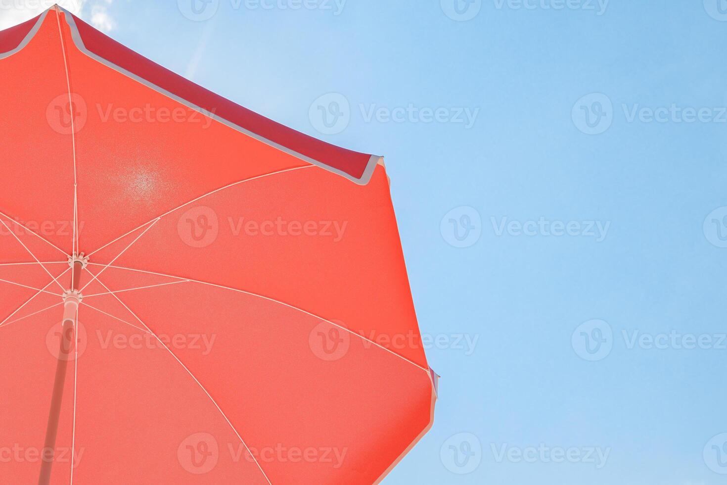 Red Beach Umbrella Against Blue Sky, Sun Protection Concept photo