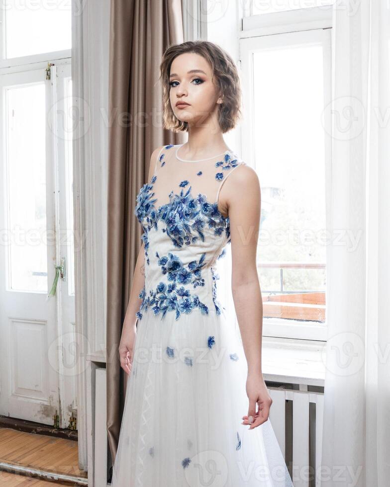 A woman in a white dress with blue flowers photo