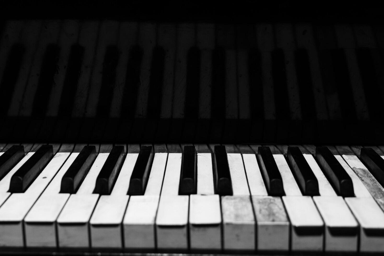 The keyboard of a classic old grand piano in close-up photo