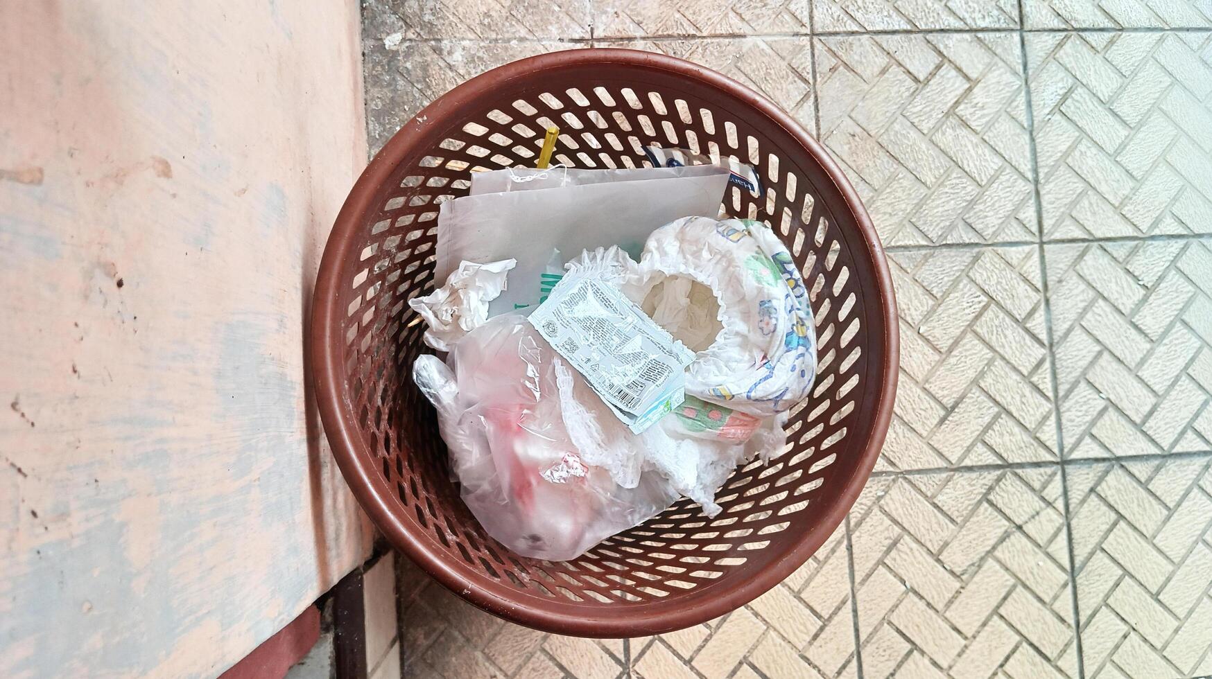 Top view of red bucket filled with household waste photo