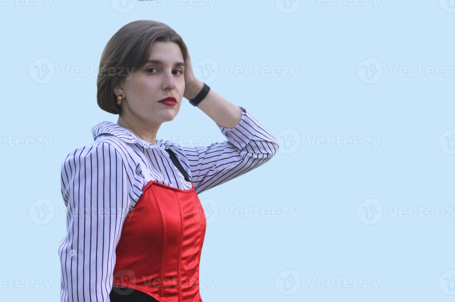 Stylish Caucasian girl in a white shirt and red top, isolated on a blue background. Free space for text. photo