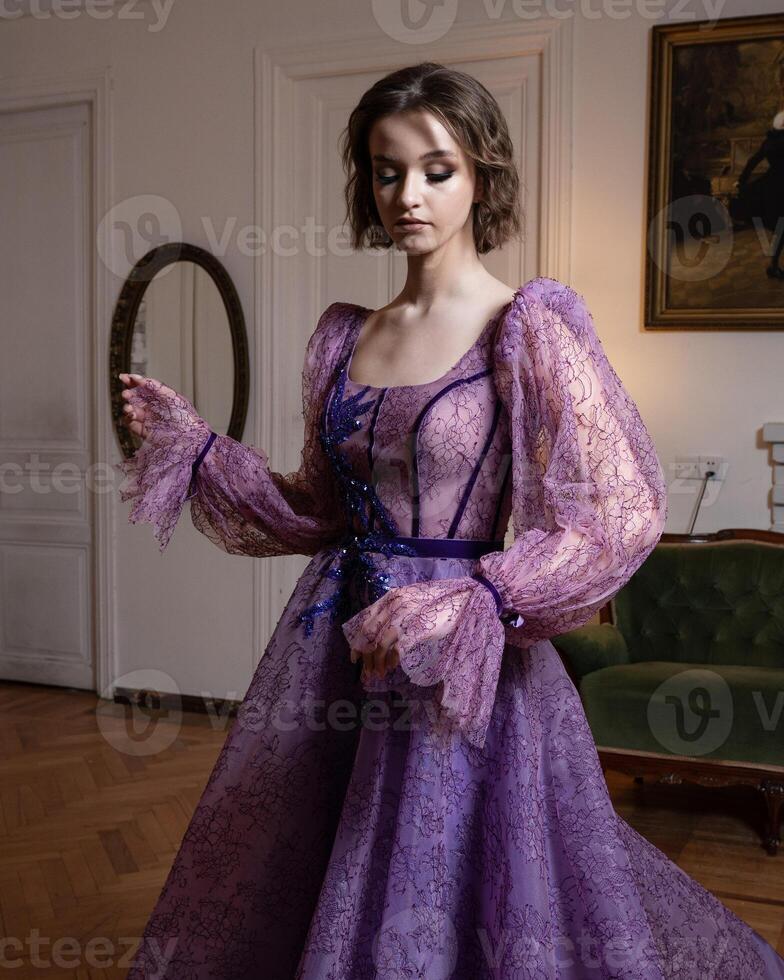 A woman in a purple dress with a blue ribbon on the bottom. photo