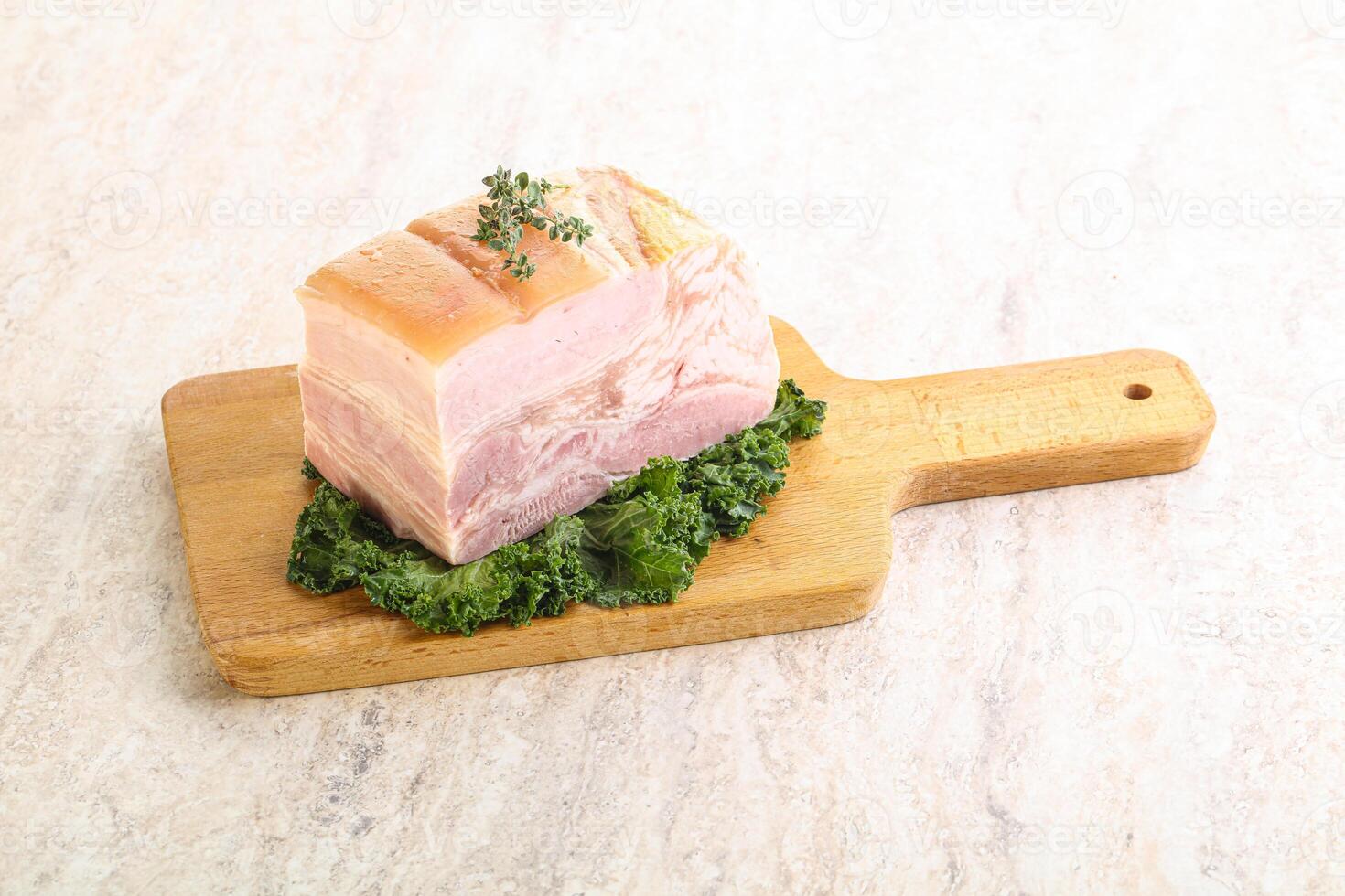 Cut of pork bacon over board photo