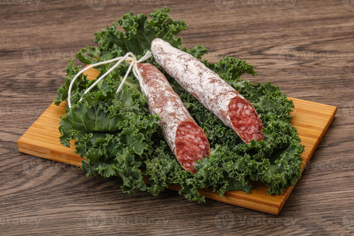 Spanish Fuet sausage with salad leaves photo
