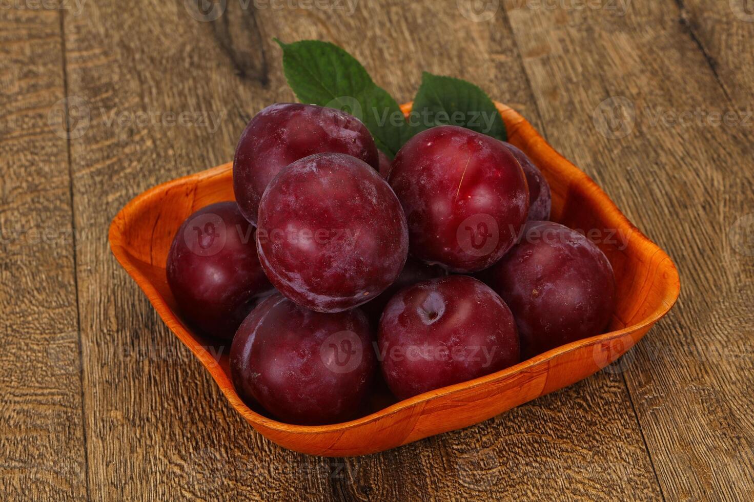 Plum heap in the wooden basket photo