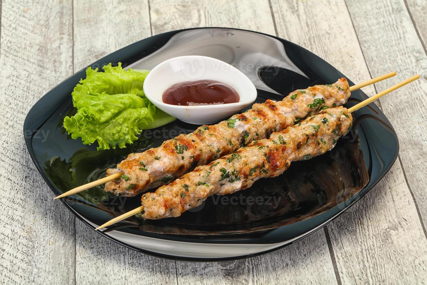 Minced pork skewer kebab with sauce photo