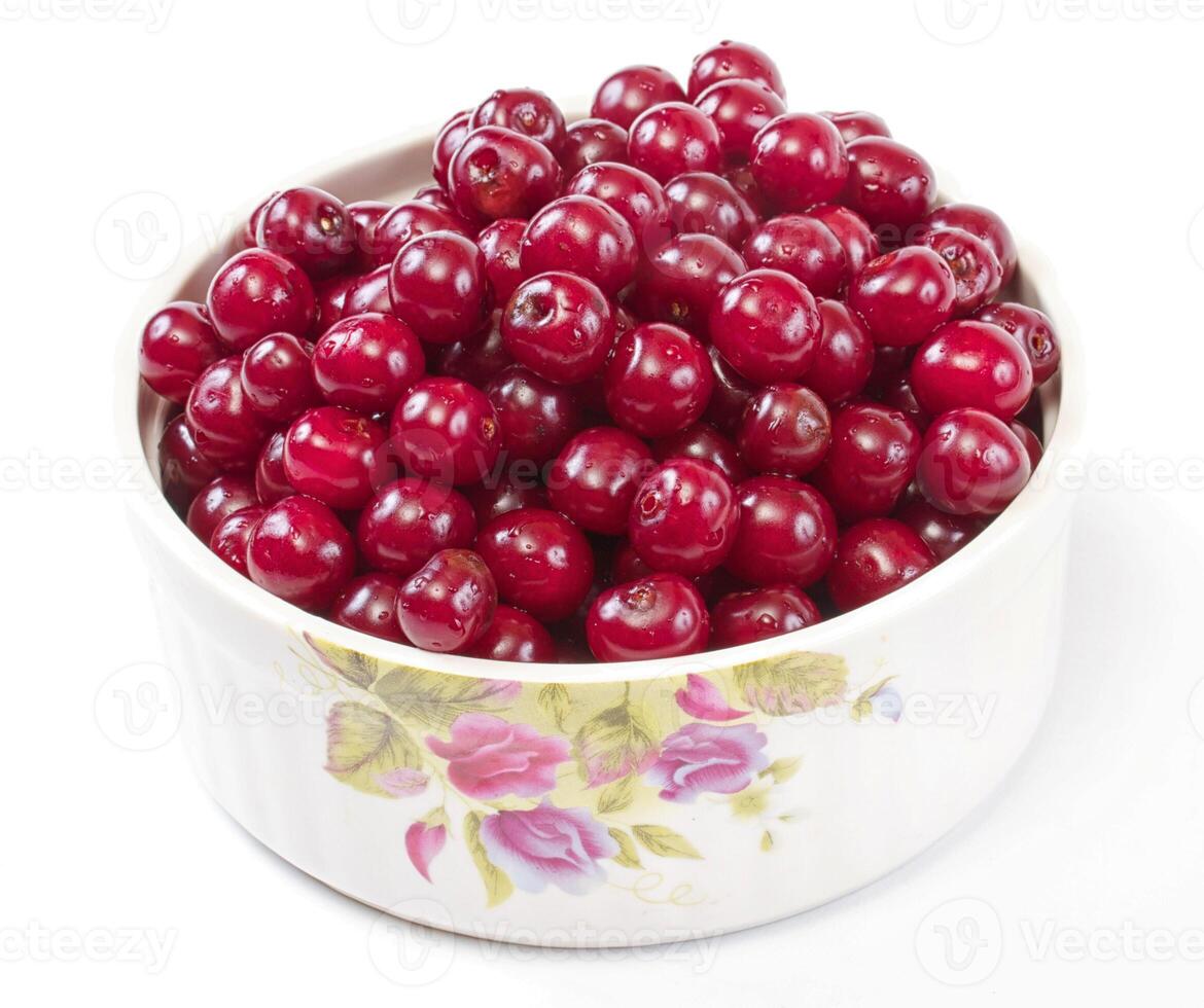 Bowl with ripe cherries. Isolated on a white background. photo