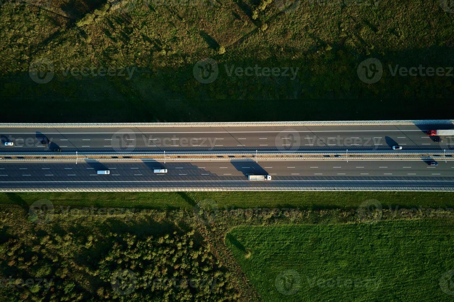 Cars driving on highway road near forest trees, top view photo