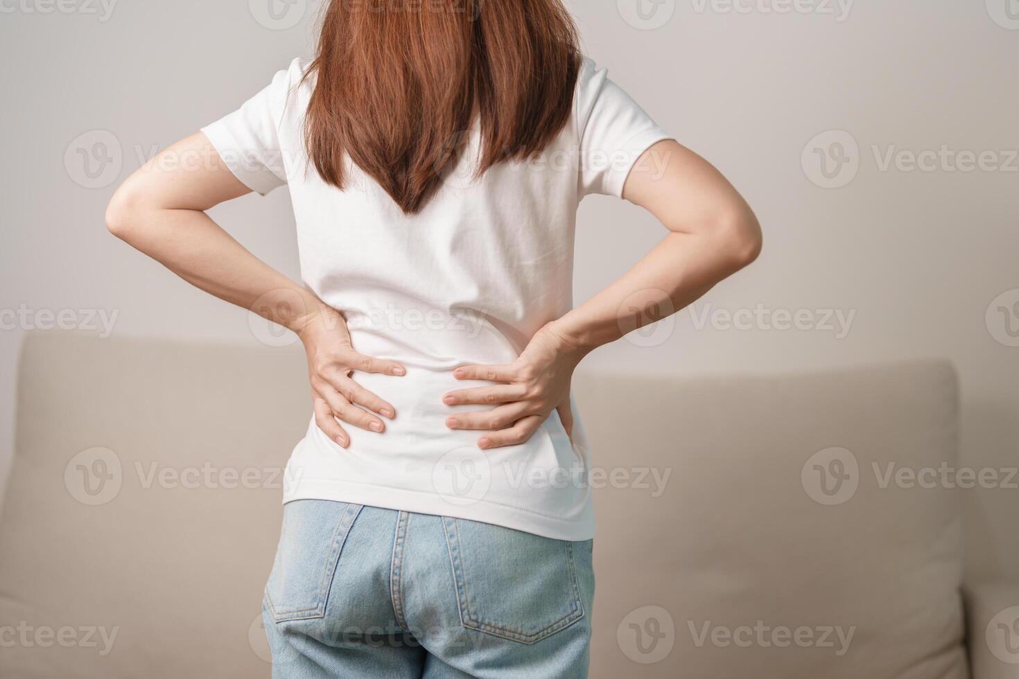 woman having back body ache during sitting on Couch at home. adult female with muscle pain due to Piriformis Syndrome, Low Back Pain and Spinal Compression. Office syndrome and medical concept photo