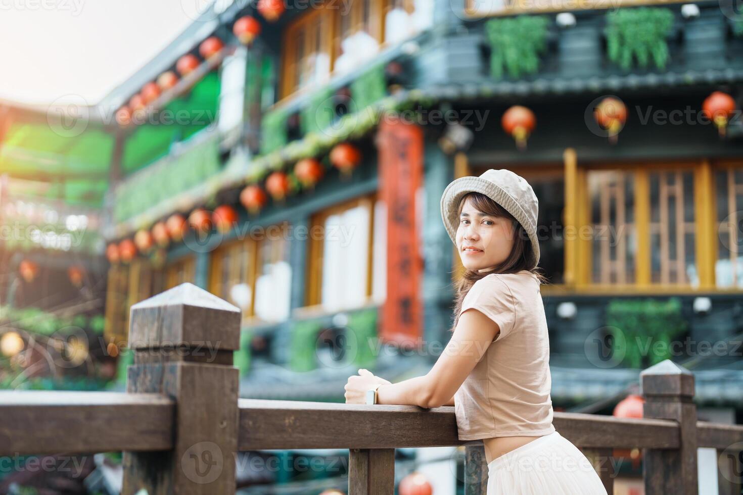 woman traveler visiting in Taiwan, Tourist with hat sightseeing in Jiufen Old Street village with Tea House background. landmark and popular attractions near Taipei city . Travel and Vacation concept photo