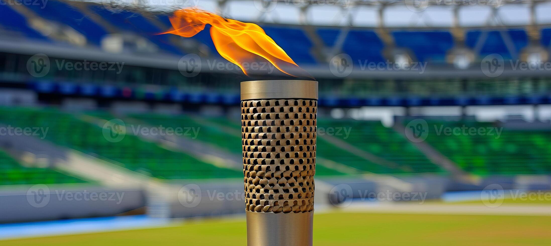 AI generated Olympic torch flame burning against blurred sports arena with copy space for text placement photo