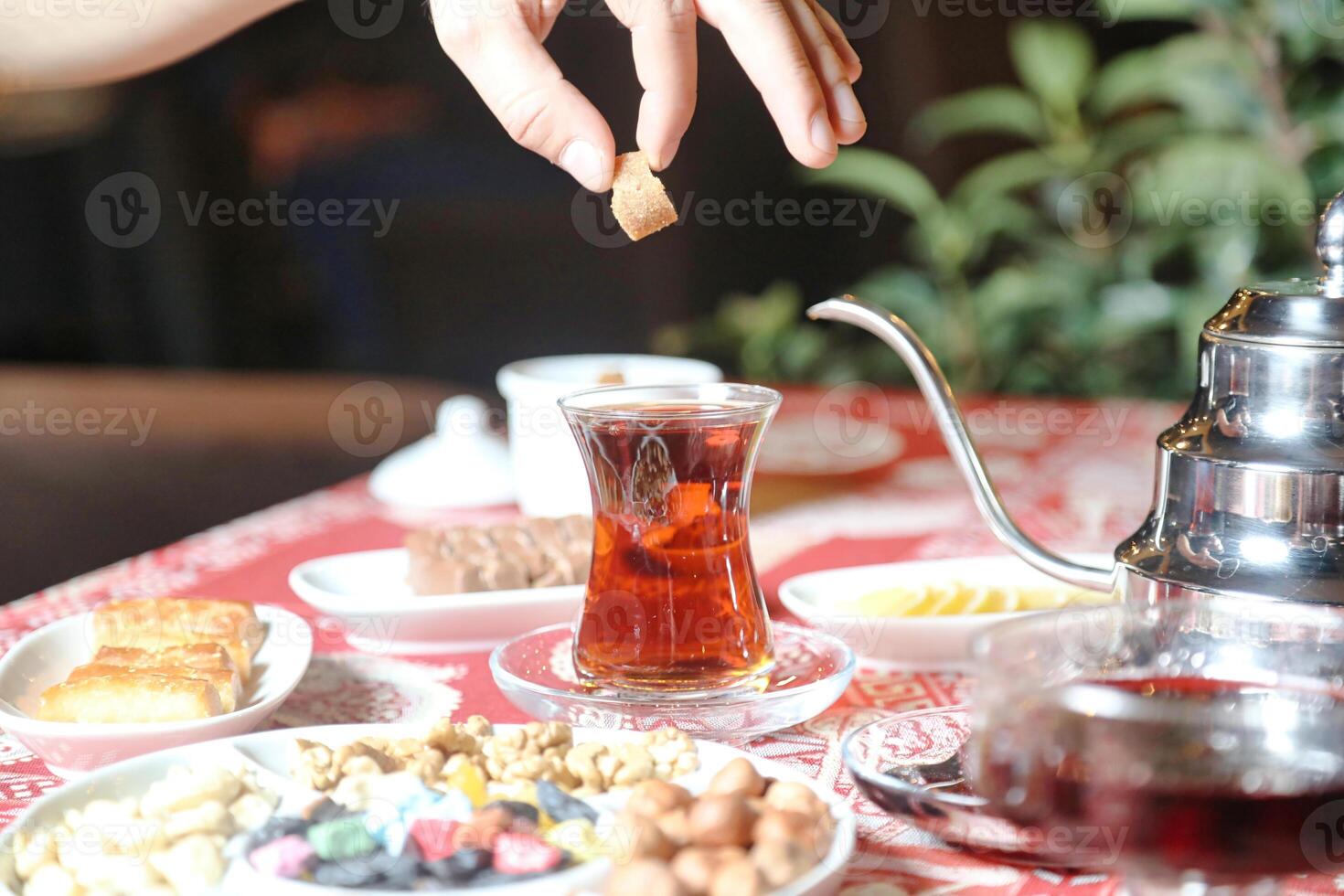 Person Pouring Tea Into Ceramic Teapot photo