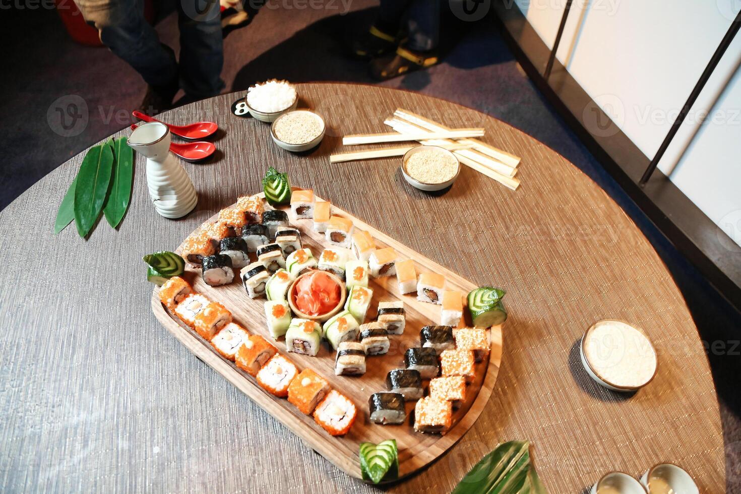 Wooden Table Covered in Assorted Sushi Rolls photo