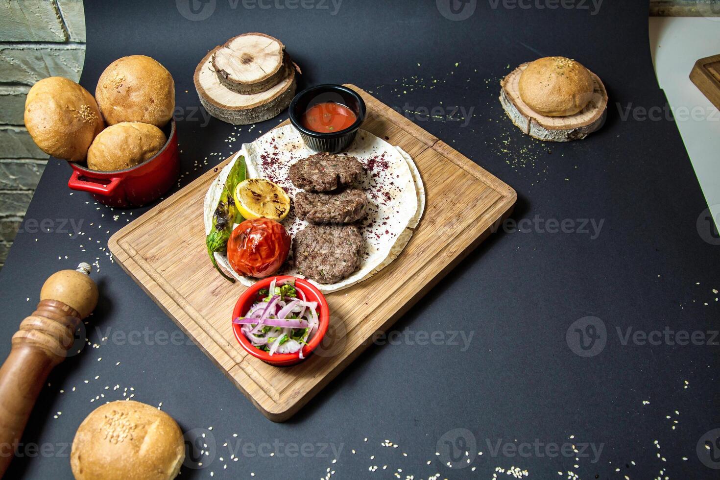 Wooden Cutting Board With Hamburgers and Assorted Food photo