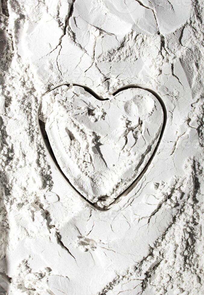 Heart shape on white powder. Valentine's day concept. Postcard, congratulations on the holiday. View from above. photo