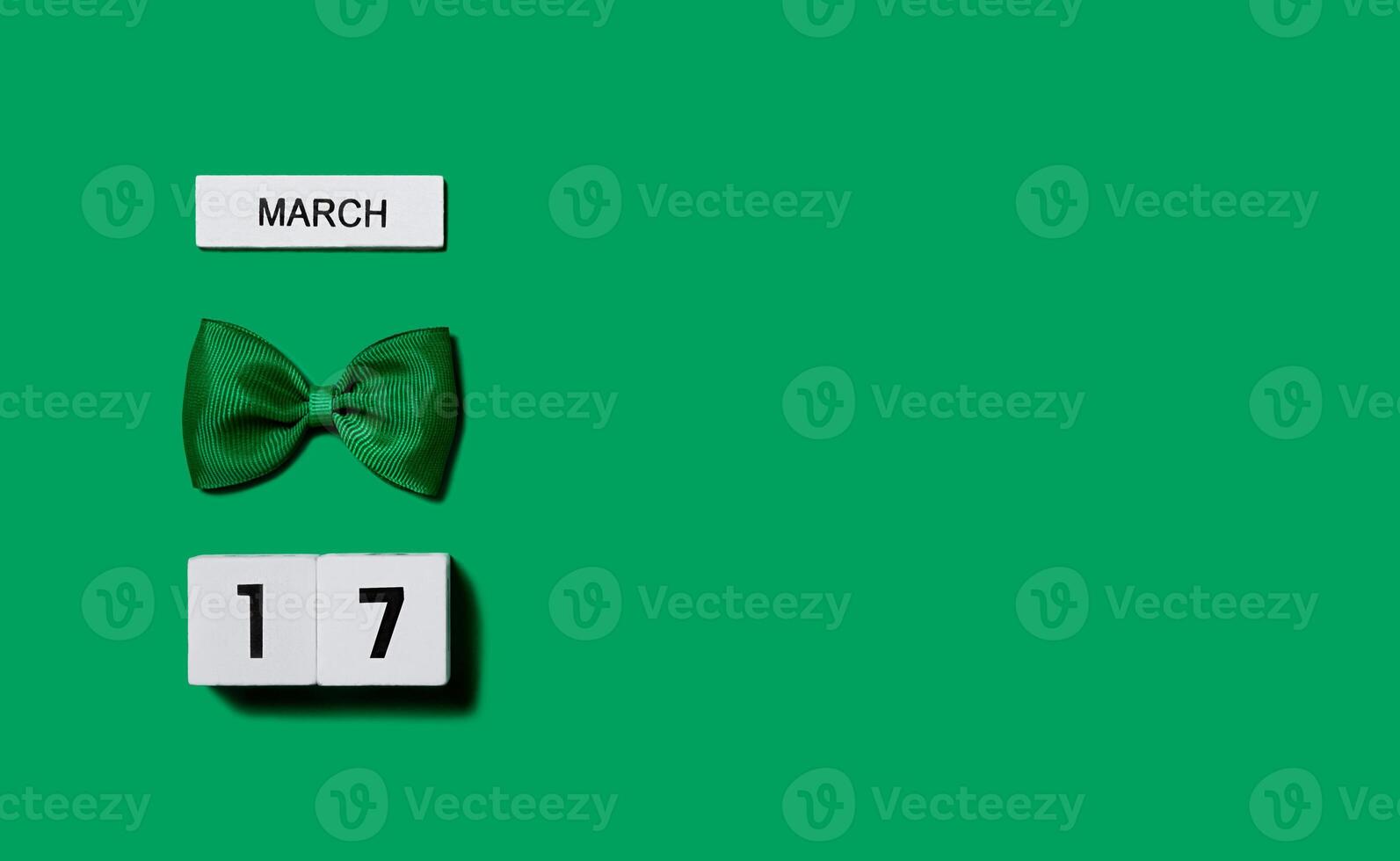 St. Patrick's Day background. Wooden calendar with a leprechaun bow on a green background. Banner. Copy space. photo