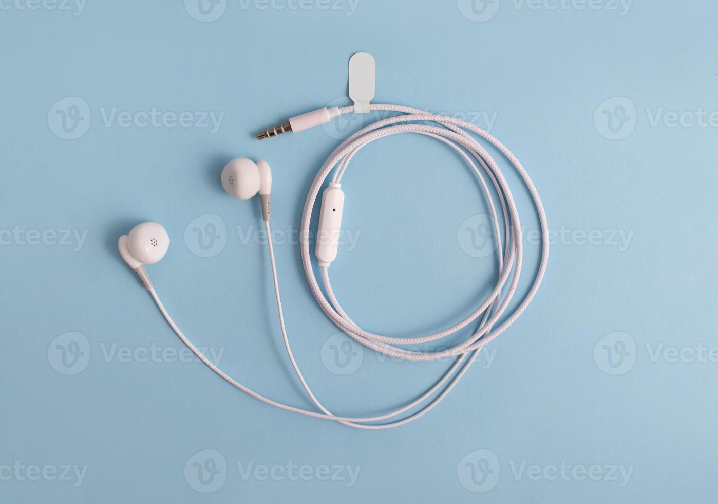 White headphones with a label on a blue background. Music concept. Copy space. photo