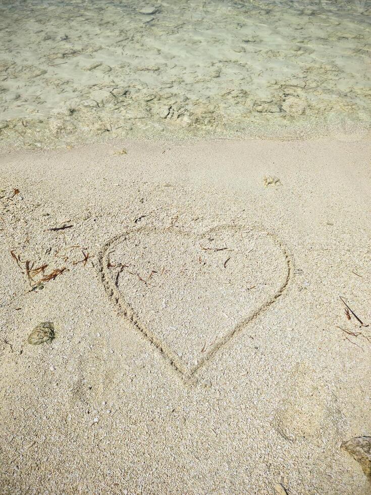 A romantic heart painted in the sand of the Maldives. photo