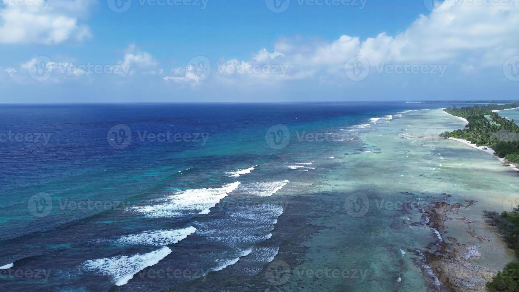 Drone view of paradise islands of the Maldives with coral reefs under the waves of blue the Indian Ocean. photo