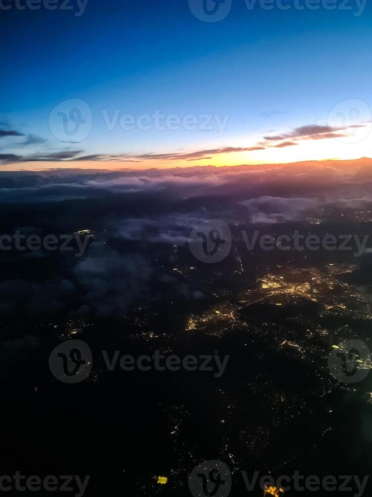 View from an airplane window at night of a city with many lights. photo