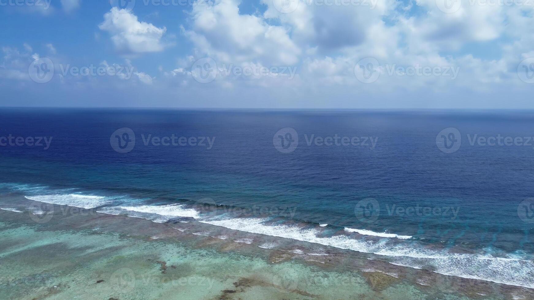 Drone view of paradise islands of the Maldives with coral reefs under the waves of blue the Indian Ocean. photo