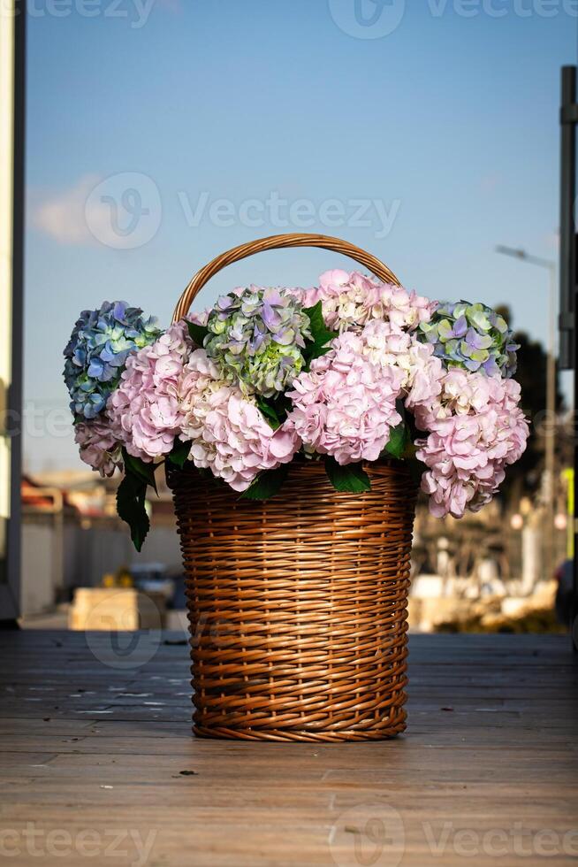 mimbre cesta desbordante con púrpura y azul flores foto