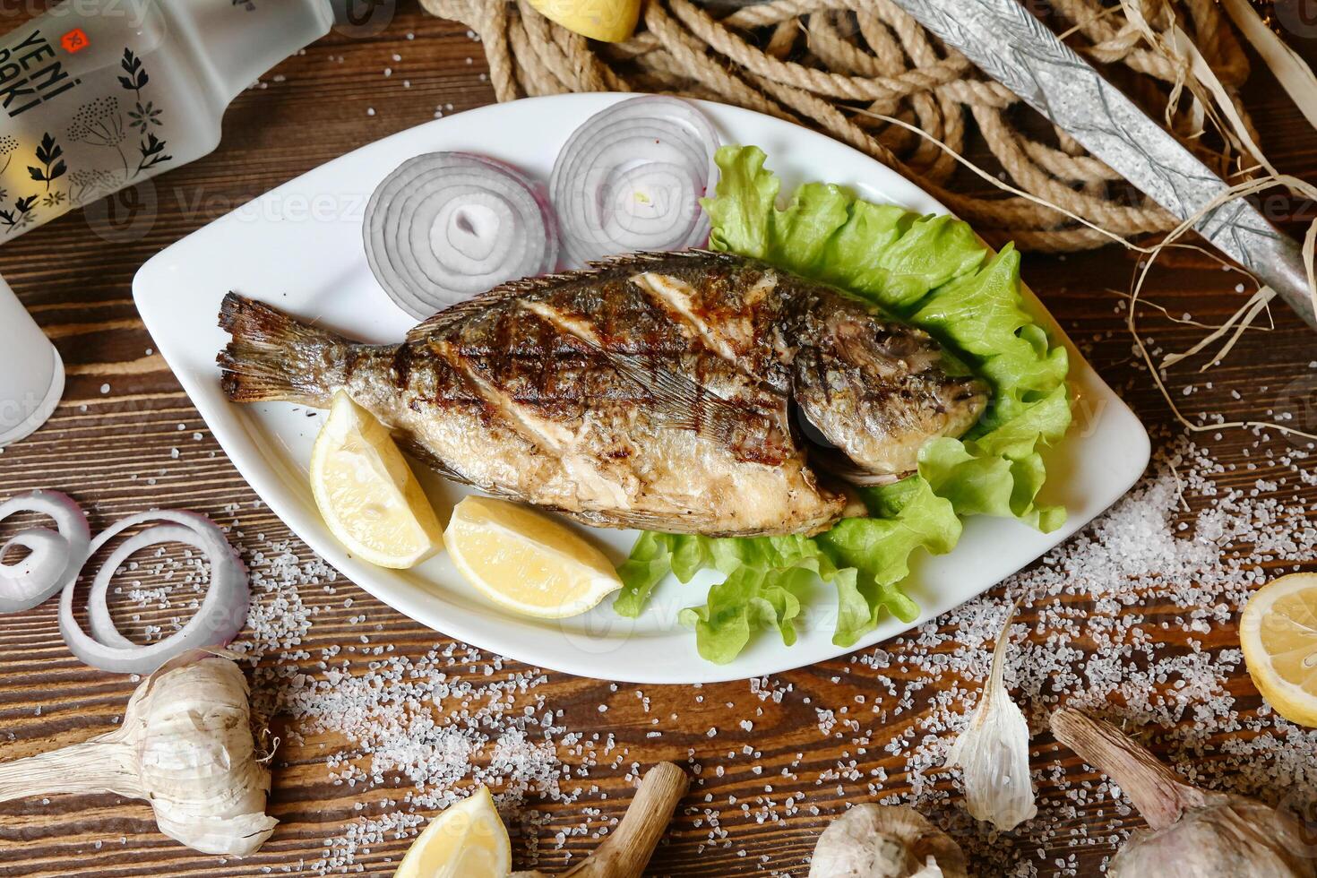 Fresh Fish With Lemons and Garlic on a Plate photo