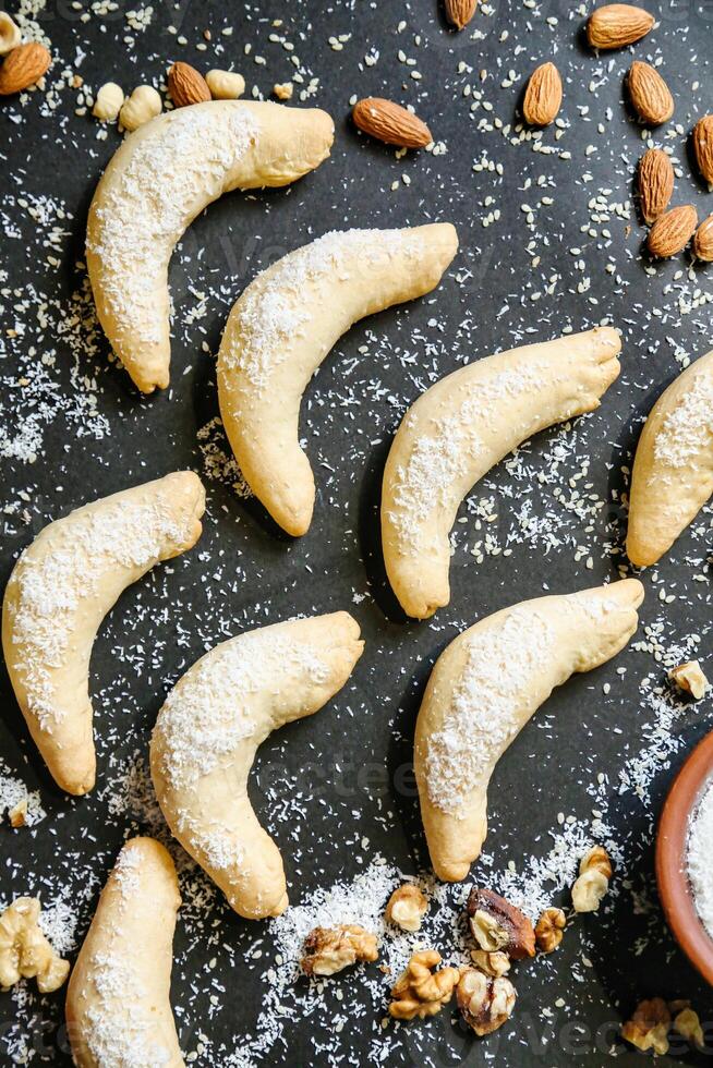 Table With Assorted Cookies, Nuts, and a Bowl of Powdered Sugar photo