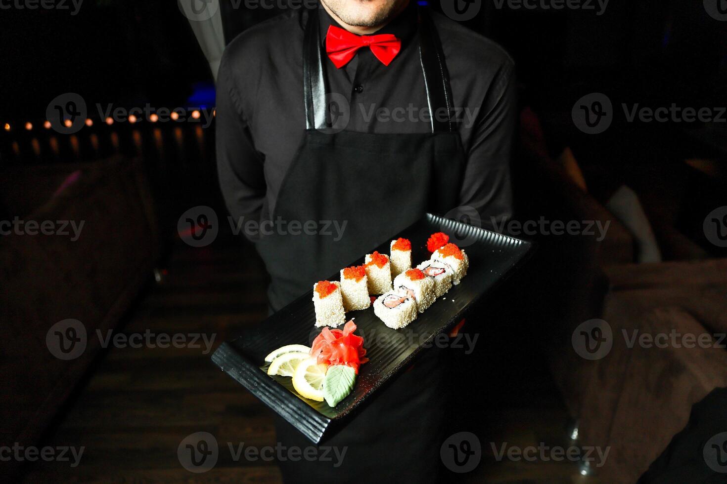 hombre participación bandeja de Sushi en japonés restaurante foto