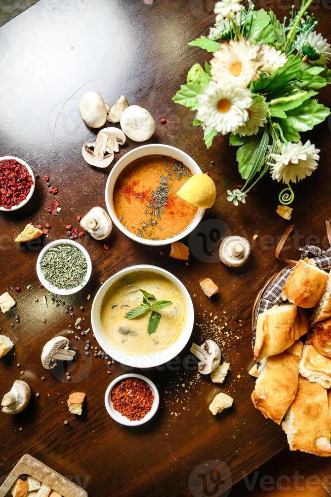 Table Adorned With Bowls of Steaming Soup and Fresh Bread. photo